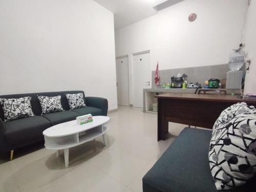 a living room with a couch and a table at Surabaya Homestay Golden Rose Juanda in Gabung
