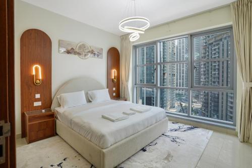 a bedroom with a large bed and large windows at 13Stnd- Luxury Living in Downtown Near Burj Khalifa & World Trade Center in Dubai