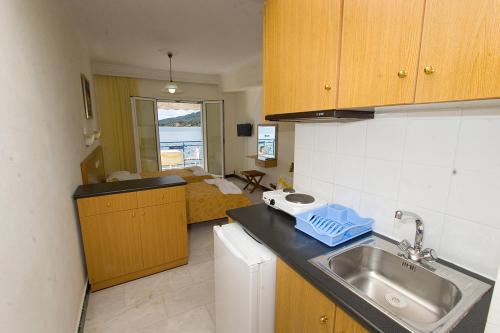 ルトラ・エディプソスにあるGrand Apartmentsのシンク付きのキッチンとベッド付きの部屋