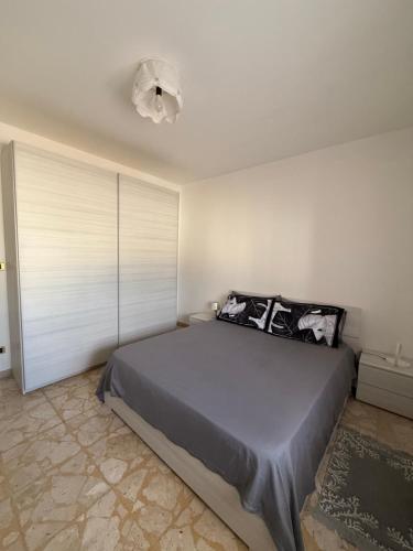 a bedroom with a large bed and a chandelier at La terrazza in Marina di Gioiosa Ionica