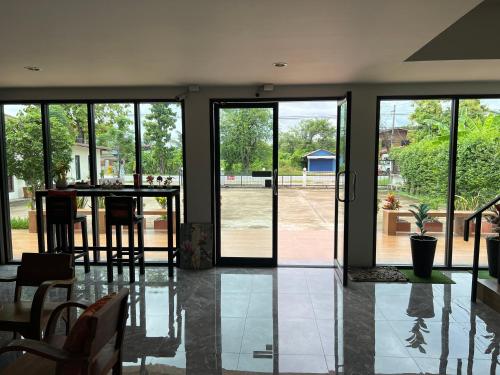 a room with glass doors and a table with chairs at Ma Room Place Sukhothai Resort in Sukhothai