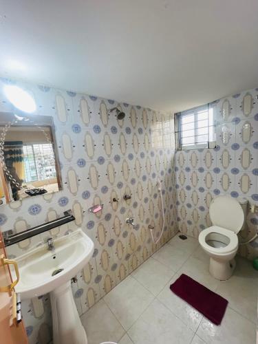 un baño con lavabo e inodoro en Gulshan Guest House, en Dhaka