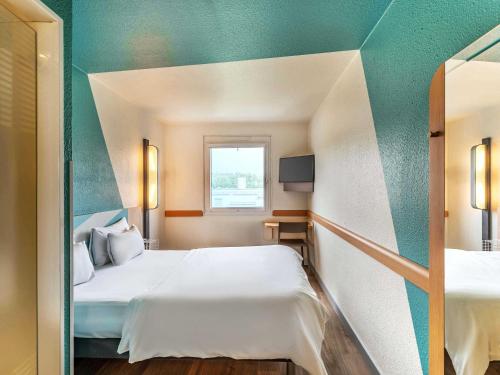 a hotel room with a bed and a window at B&B HOTEL Köln-Porz in Cologne