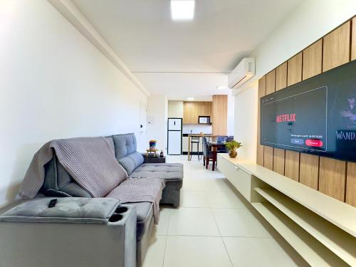 a living room with a couch and a flat screen tv at Apto 2 Quartos PISCINA Churrasqueira Wi-Fi Ar Condicionado Cozinha Complata Vaga de Garagem 400m PRAIA Ideal para Famílias ou Amigos Reserve Agora in Piçarras