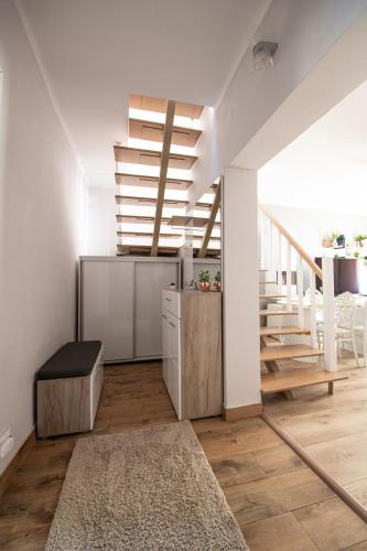 a living room with a staircase and white walls at The Royal House 102 sqm 2BR Two Floor Apartment in Hunedoara