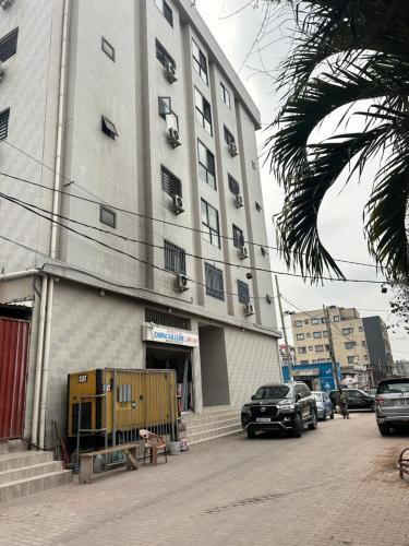 a large building with cars parked in front of it at Easy home in Brazzaville