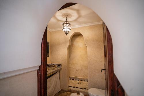 baño con aseo y lámpara de araña en Riad Chams Marrakech, en Marrakech