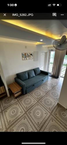 a living room with a blue couch in a room at Paradise-Vadanappally Beach Villa for 4-5 adults in Irimbranallūr