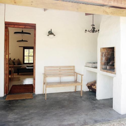 a living room with a wooden bench in a room at Watsonia Cottage at Waboom Family Farm in Stanford