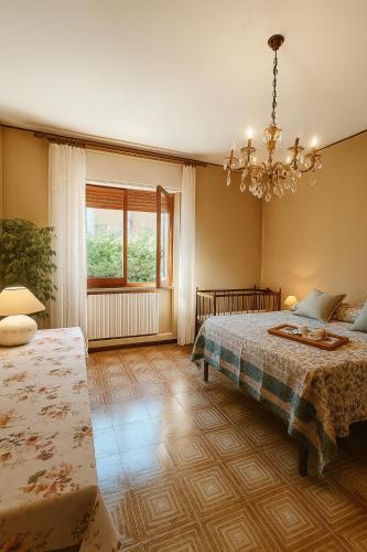 Un dormitorio con dos camas y una lámpara de araña. en Tina's House, en Cagliari