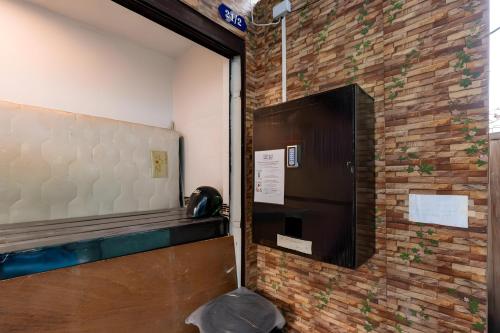 - une porte dans une pièce dotée d'un mur en briques dans l'établissement The Hidden Sao Chingcha - ถนนดินสอ xPro, à Bangkok