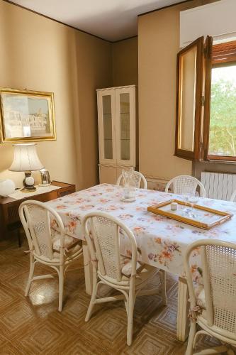 Un comedor con una mesa con sillas blancas y una mesa para comer. en Tina's House, en Cagliari