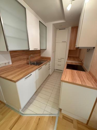 Una cocina con gabinetes blancos y un fregadero. en Ferienwohnung Seebach, en Eferding