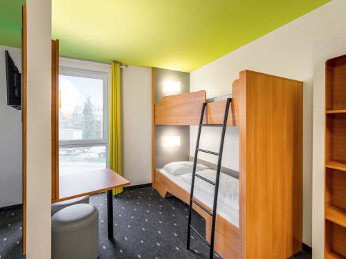 a small room with a bunk bed and a desk at B&B Hotel Krefeld in Krefeld