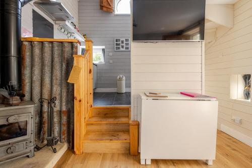 a tiny house with a kitchen and a stove at The Scullery - a quirky annex with wood fire in Huddersfield