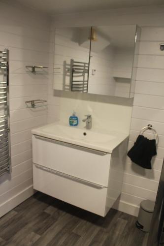 a white bathroom with a sink and a mirror at The Scullery - a quirky annex with wood fire in Huddersfield