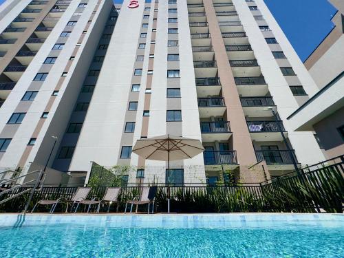 a hotel with a pool in front of a building at Apto 2 Quartos PISCINA Churrasqueira Wi-Fi Ar Condicionado Cozinha Complata Vaga de Garagem 400m PRAIA Ideal para Famílias ou Amigos Reserve Agora in Piçarras