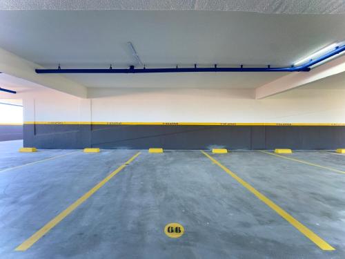 an empty parking lot with a yellow ball on the floor at Apto 2 Quartos PISCINA Churrasqueira Wi-Fi Ar Condicionado Cozinha Complata Vaga de Garagem 400m PRAIA Ideal para Famílias ou Amigos Reserve Agora in Piçarras