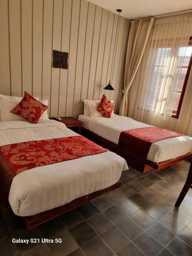 a hotel room with two beds and a window at Day Sunrise Boutique Hotel in Siem Reap