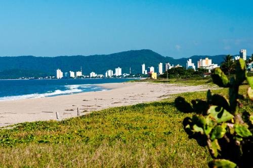 a view of a beach with a city in the background at Apto 2 Quartos PISCINA Churrasqueira Wi-Fi Ar Condicionado Cozinha Complata Vaga de Garagem 400m PRAIA Ideal para Famílias ou Amigos Reserve Agora in Piçarras
