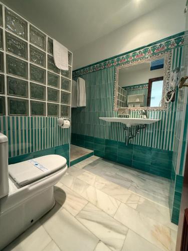 a bathroom with a toilet and a mirror at Hotel La Española in Chipiona