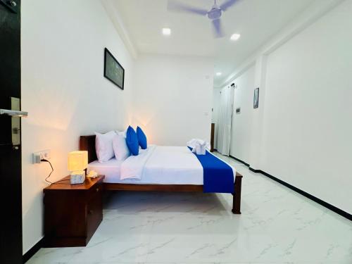 a bedroom with a bed with blue pillows at AP Pearl Palace -Tangalle in Tangalle