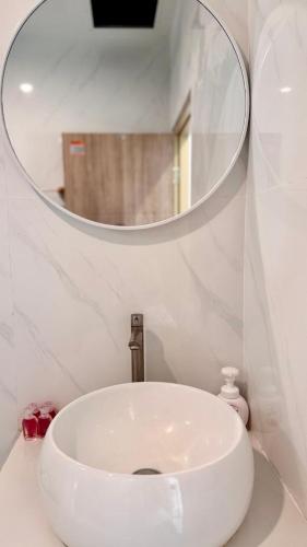a white sink in a bathroom with a mirror at White Pearl 2BR Beachfront House Malibu Seaview in Mae Haad