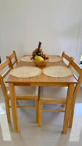 a wooden table with a bowl of fruit on it at White Pearl 2BR Beachfront House Malibu Seaview in Mae Haad