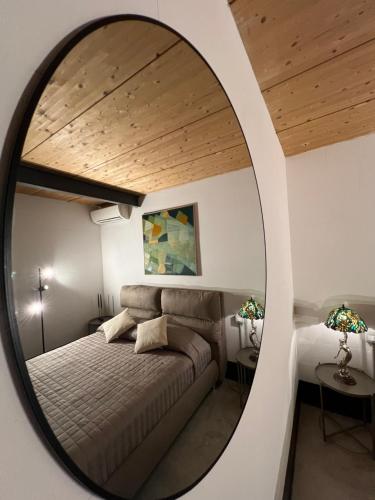 a bedroom with a bed and a round mirror at LoftDesign in Verona
