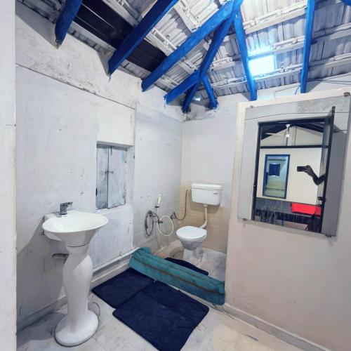a bathroom with a sink and a toilet at Coral Reef Malpe - Udupi in Udiyāvara