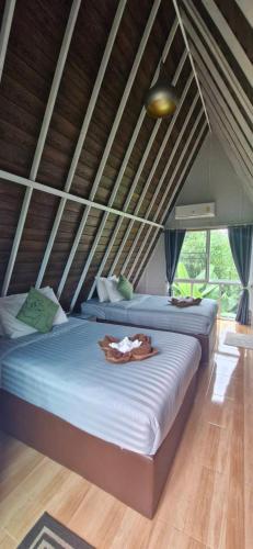 a bedroom with two beds with a robe on it at Khao Sok 99 Camp and Cafe in Khao Sok National Park