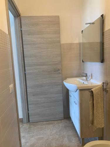 a bathroom with a shower with a sink and a mirror at CASA VACANZE gli ULIVI 23 in Sìnnai