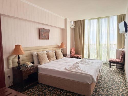 una habitación de hotel con una cama y un televisor en Shirak Hotel, en Ereván