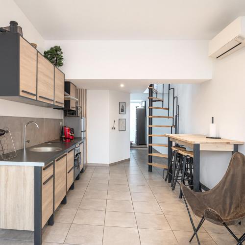 a kitchen with a counter and a table with chairs at Douceur du sud in Vitrolles
