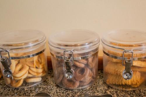 four jars filled with food sitting on a counter at Pousada do Chafariz in Mariana