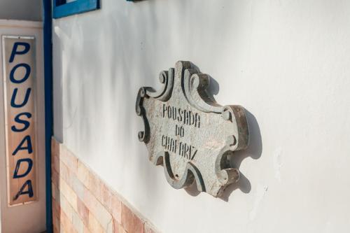 a metal sign on the side of a building at Pousada do Chafariz in Mariana