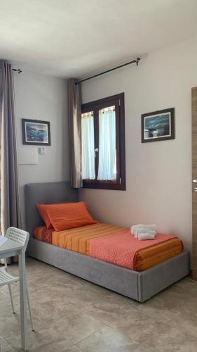 a bedroom with a bed and a window in a room at CASA VACANZE gli ULIVI 23 in Sìnnai