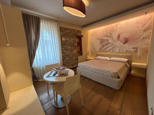 a small bedroom with a bed and a table and a tableablish at Oreste Suite in Lazise