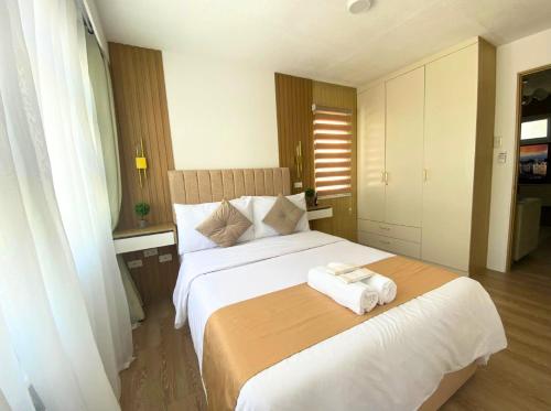 ダバオシティにあるFortress Davao QUEEN - 2BR Seawind Condo Tower 1 Near Airport, Sasa Wharfのタオルが敷かれた大きなベッドのある寝室