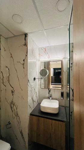 a bathroom with a sink and a mirror at Casa Nova Luxury Studio and Prime Location in Greater Noida
