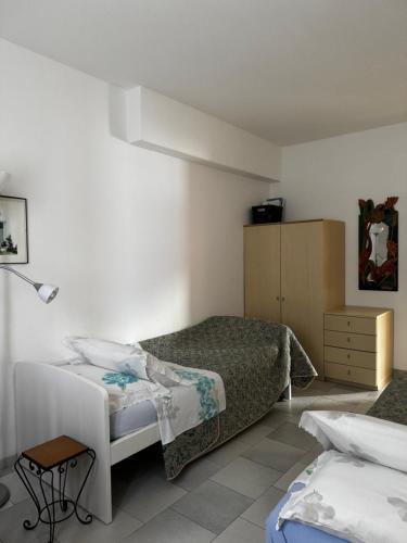 a bedroom with two beds and a table in it at Landscapesilvia Acqua in Menaggio