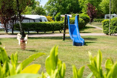 a playground with a slide in a park at Vakantiepark de Witte Berg in Ootmarsum