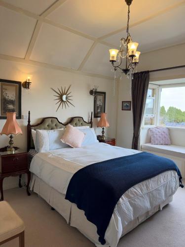 a bedroom with a large bed and a chandelier at Echo point Cottage in Katoomba