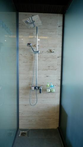 a shower in a bathroom with a wooden wall at MD Hotel in Mỹ Lộc