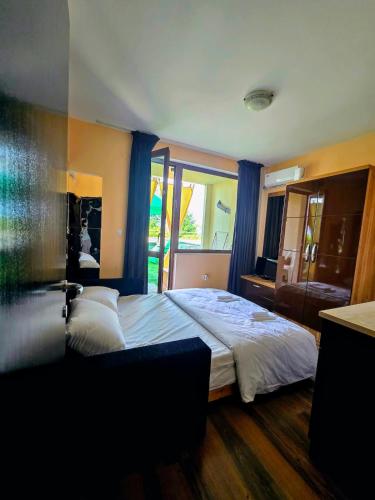 a bedroom with a large bed with blue curtains at Apartment - Studio Cucetno in Sandanski