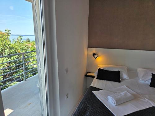 a bedroom with a bed and a balcony at Bed & Breakfast Dora in Rovanjska