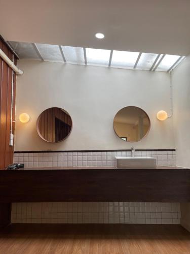 a bathroom with two mirrors and a sink at Moo Haus 