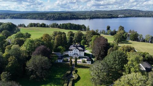 an aerial view of a house on the shore of a lake at Baldersnäs Herrgård in Dals Långed