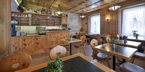 a restaurant with tables and chairs and a kitchen at Hotel Acla Filli in Zernez
