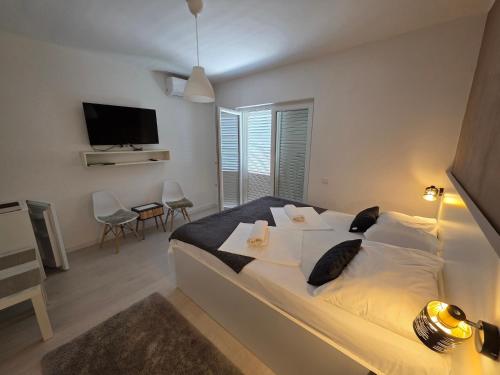 a bedroom with a large bed and a television at Bed & Breakfast Dora in Rovanjska